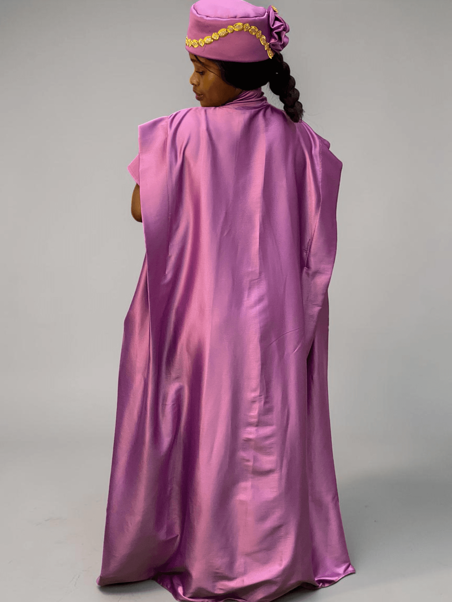 Orchid purple satin boubou gown with embellished shoulder detail and adjustable waist ties on grey studio background