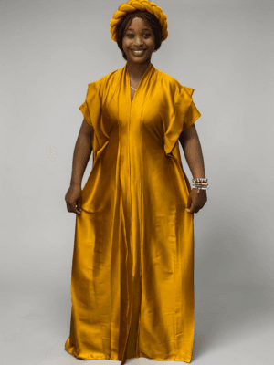 Saffron yellow satin boubou gown with wide layered sleeves and adjustable waist ties on grey studio background