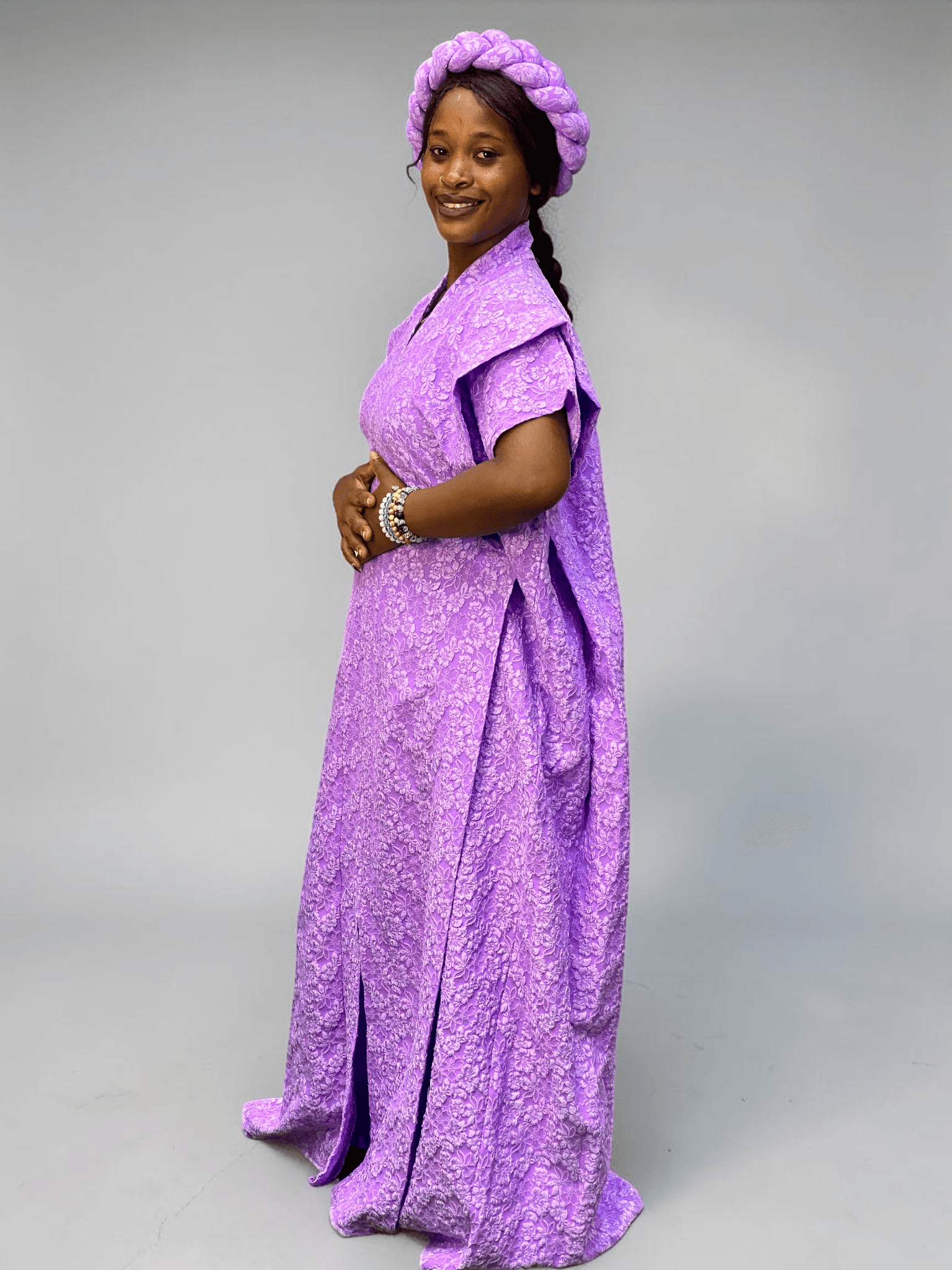 Lavender purple 3D floral gown with raised floral texture and adjustable waist ties on grey studio background