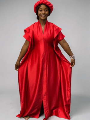 Crimson red satin boubou gown with wide sleeves and adjustable waist ties on grey studio background