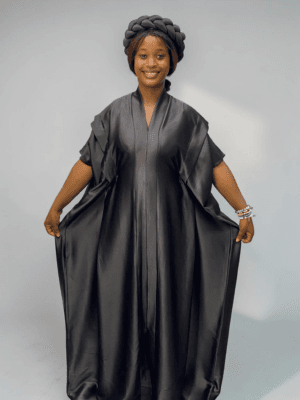 Black satin boubou gown with layered wide sleeves and adjustable waist ties on a grey studio background
