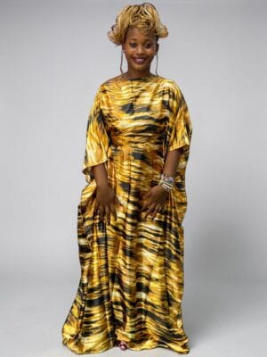 Gold black and ivory printed satin kaftan with adjustable waist ties on a grey studio background