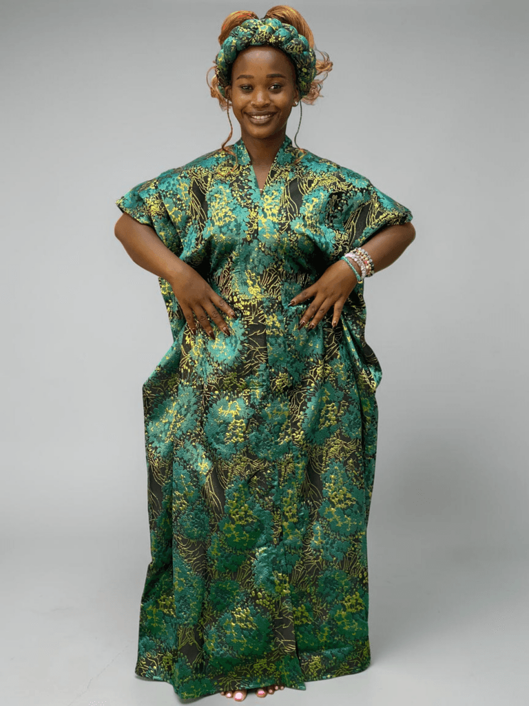 Teal green and gold floral brocade gown with woven textured pattern and adjustable waist ties on grey studio background